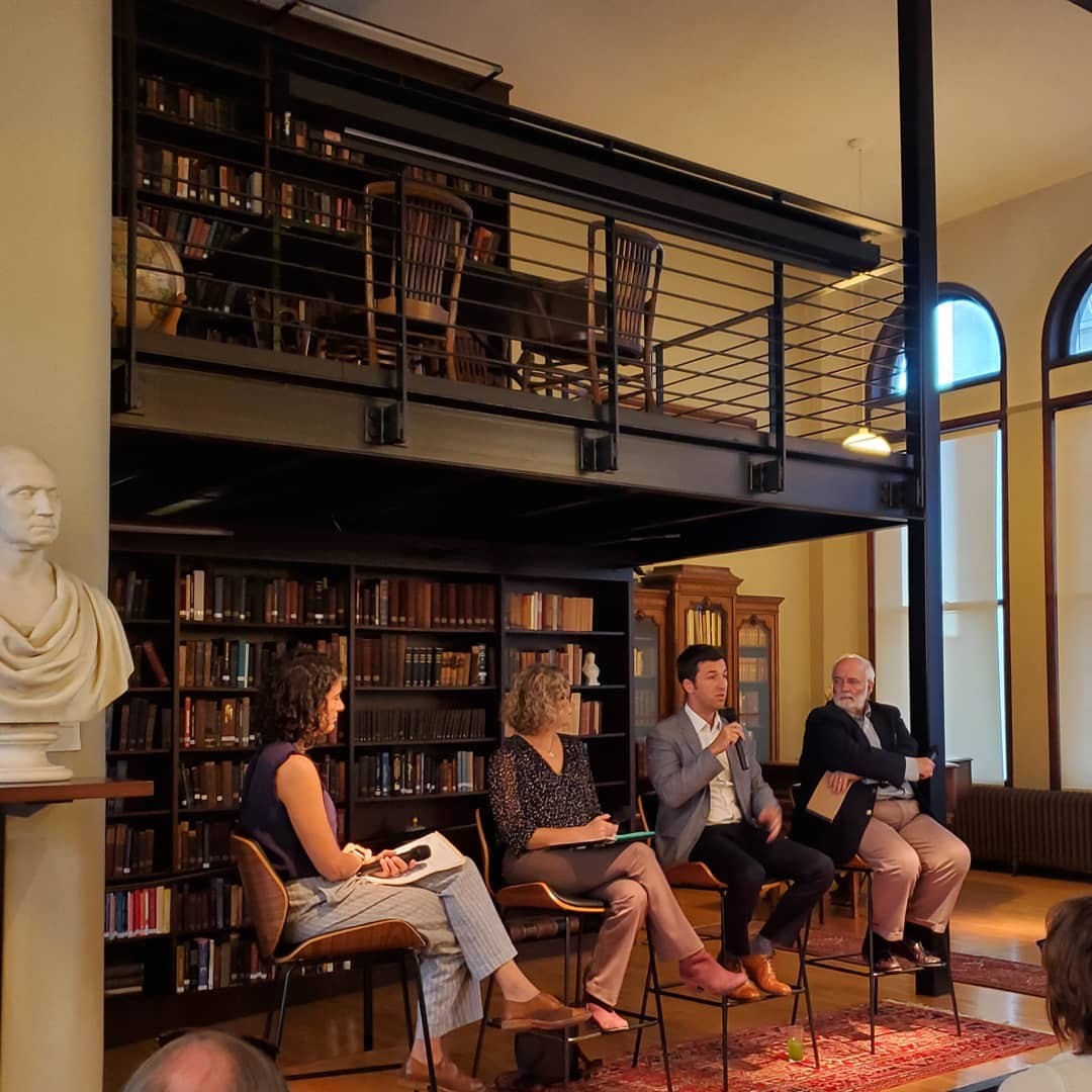 Several UC researchers and community members give a public talk at a library.