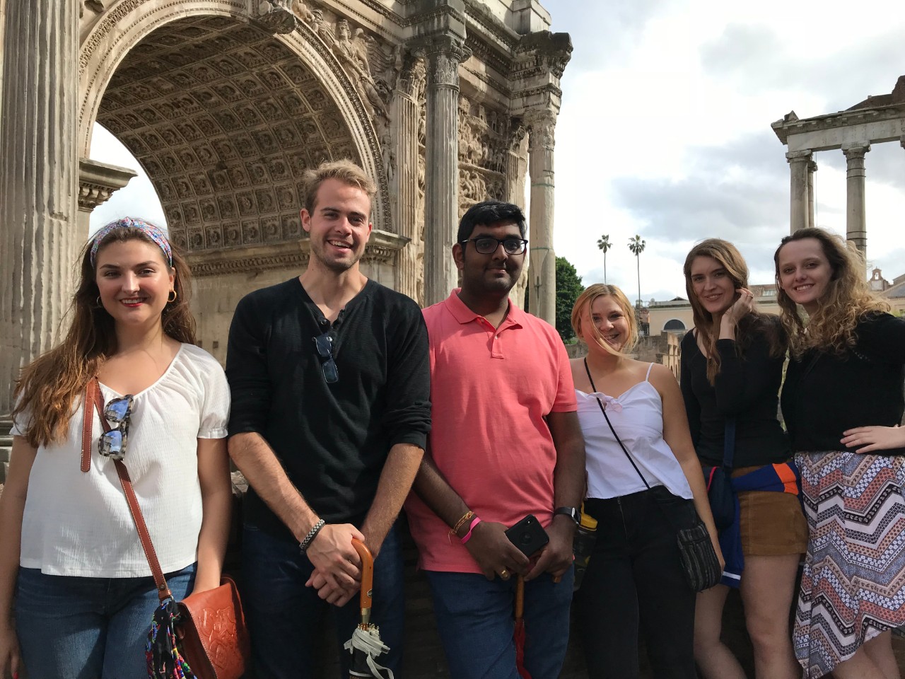 Five students pose in front of Roman Forum Arch of Septimius Severus.