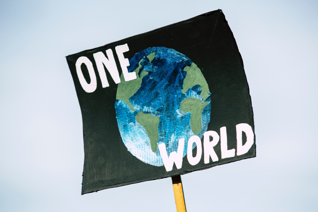 Poster with drawing of a globe with text that reads "One World" to provide a visual cue for the Collaborative Sustainability Lab
