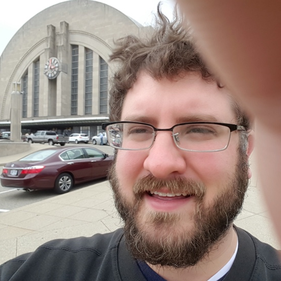 A cropped color photo of Jay Arns smiling outside the Cincinnati Museum Center. 