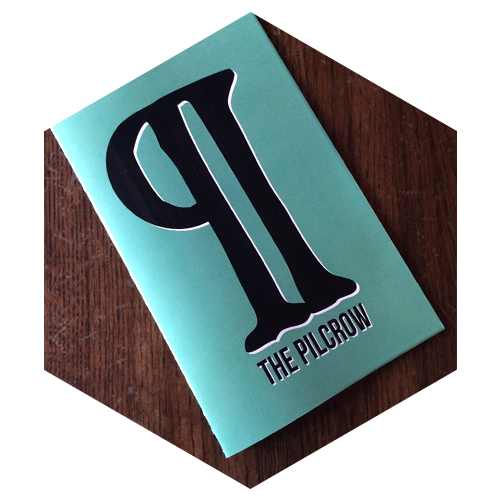 Hexagon shaped image of a teal colored book called "The Pilcrow" on a wooden talble, links to Opportunities for companies and agencies